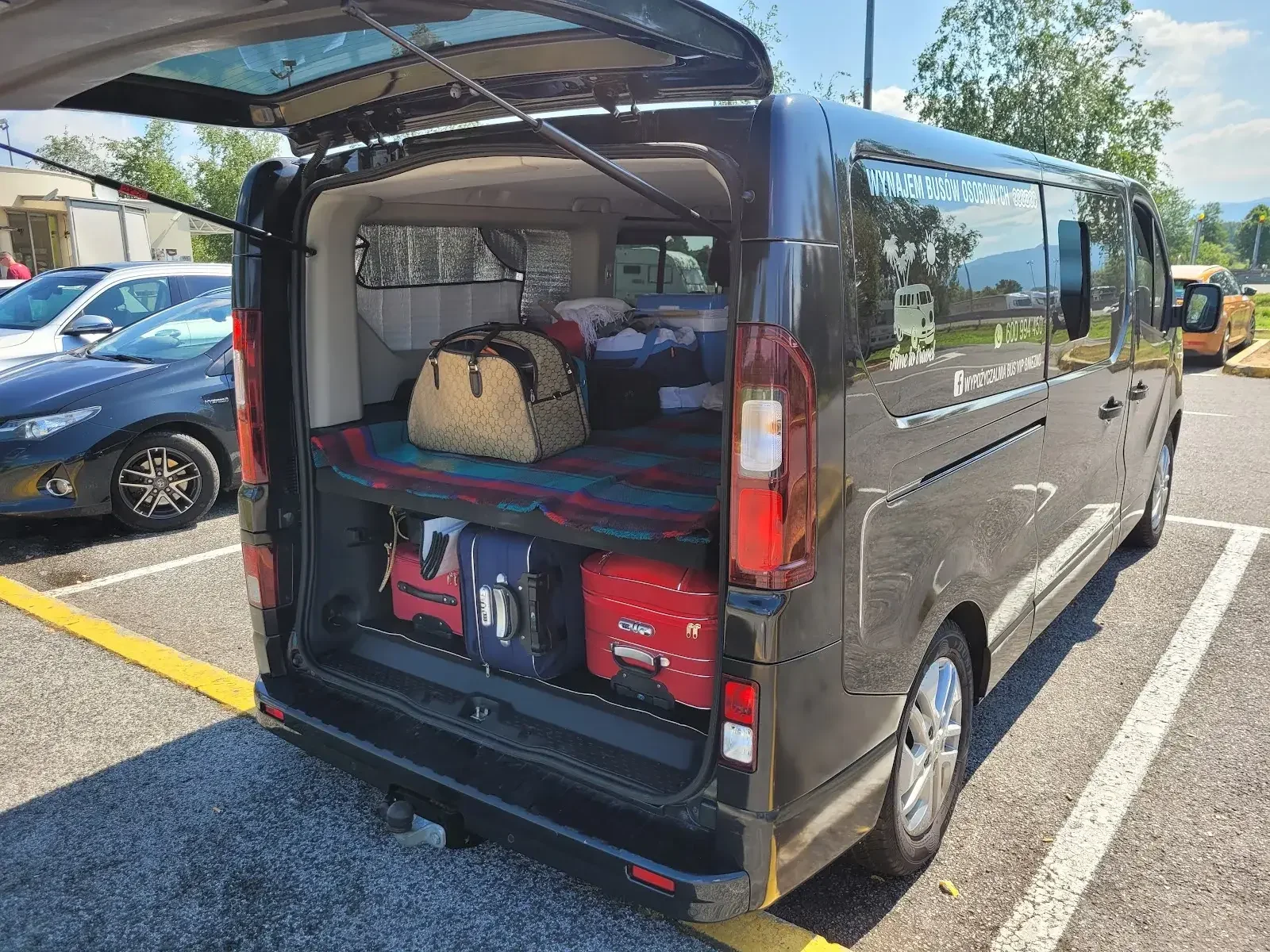 Interior de la furgoneta VIP — asientos negros y amplio maletero